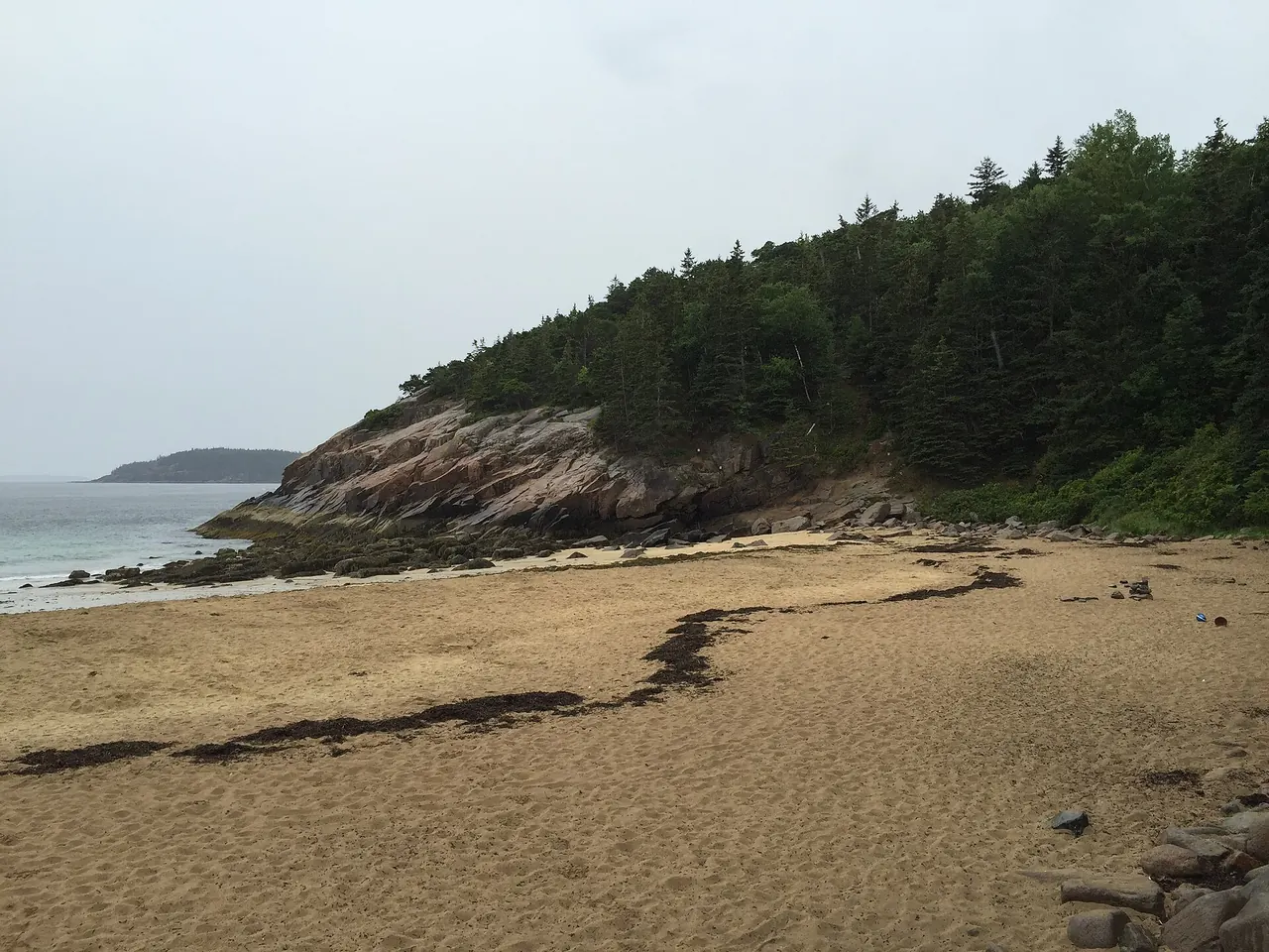 Sand Beach in Acadia National Park with granite headlands on either side of the cove
