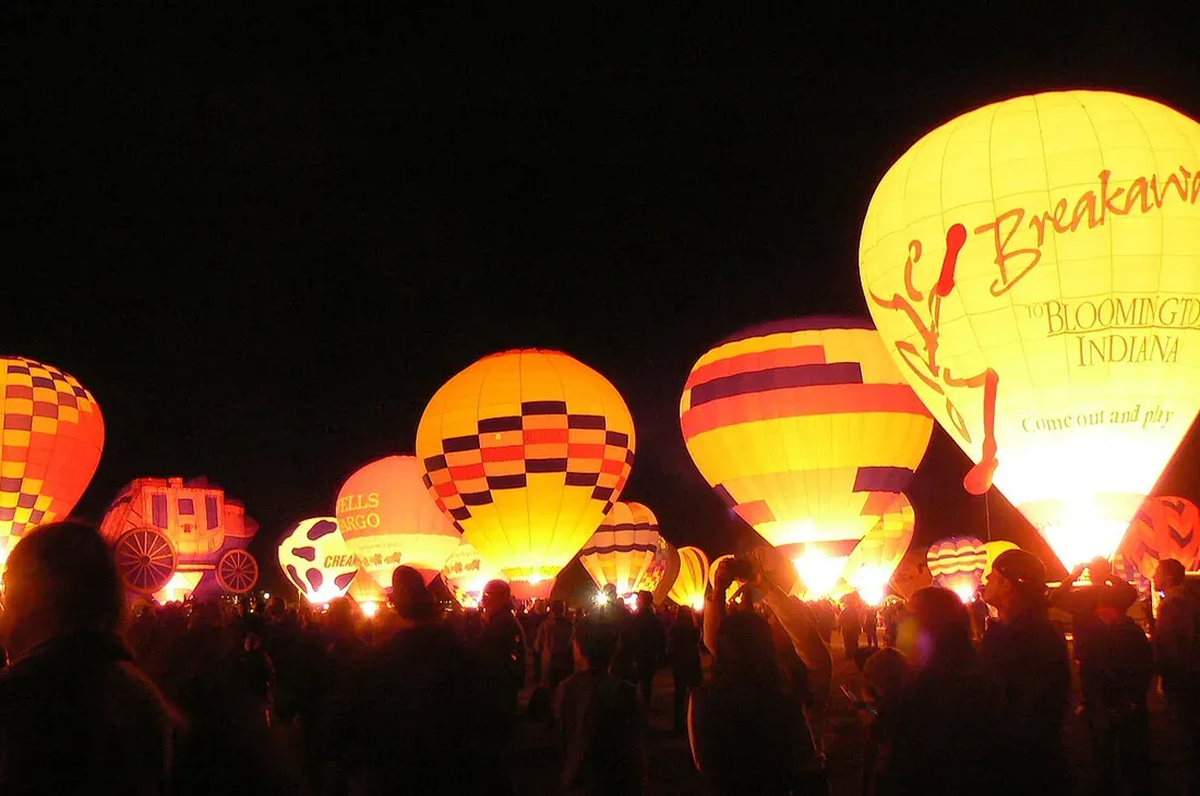 Hot air balloons lit from within during an evening glow event
