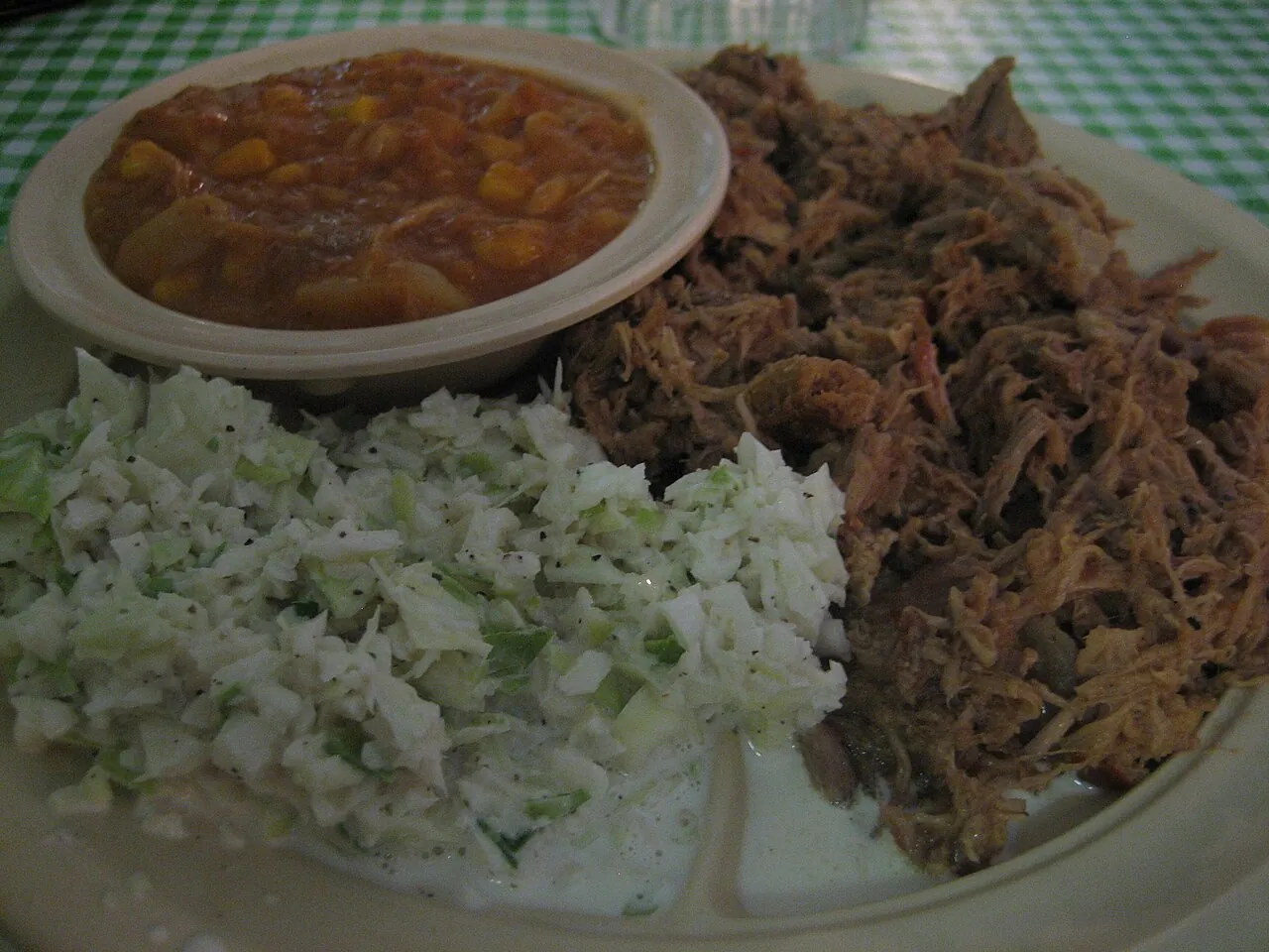 A tray of chopped North Carolina barbecue with coleslaw, hush puppies and Brunswick stew