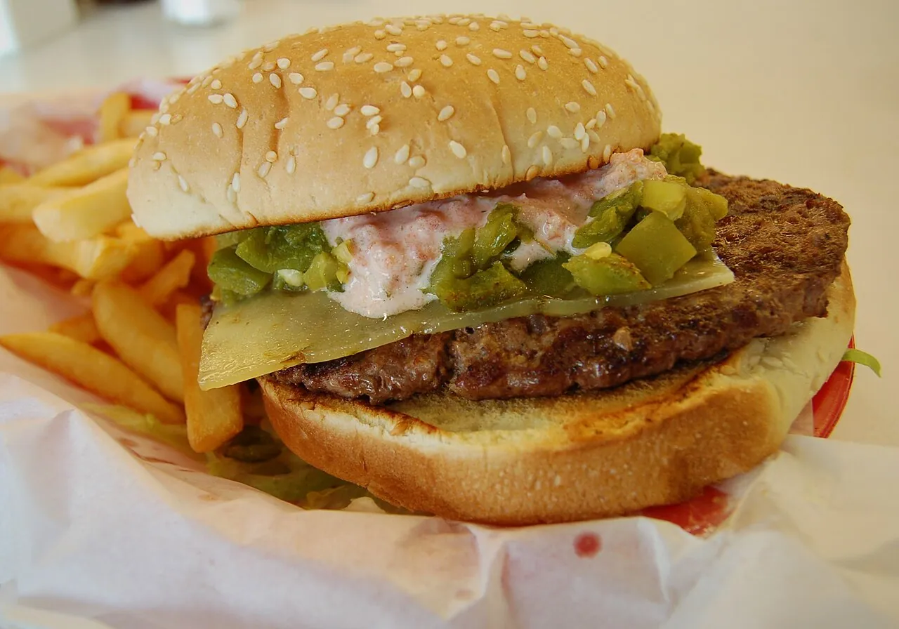 A green chile cheeseburger loaded with roasted New Mexico chiles at a roadside stand in Hatch