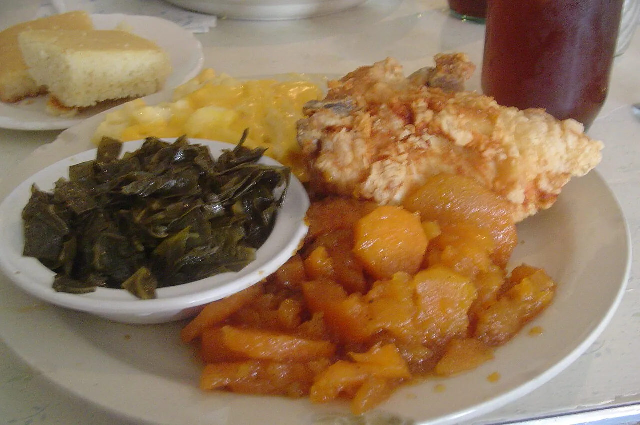 A soul food dinner of fried chicken, collard greens, macaroni and cheese, yams and cornbread
