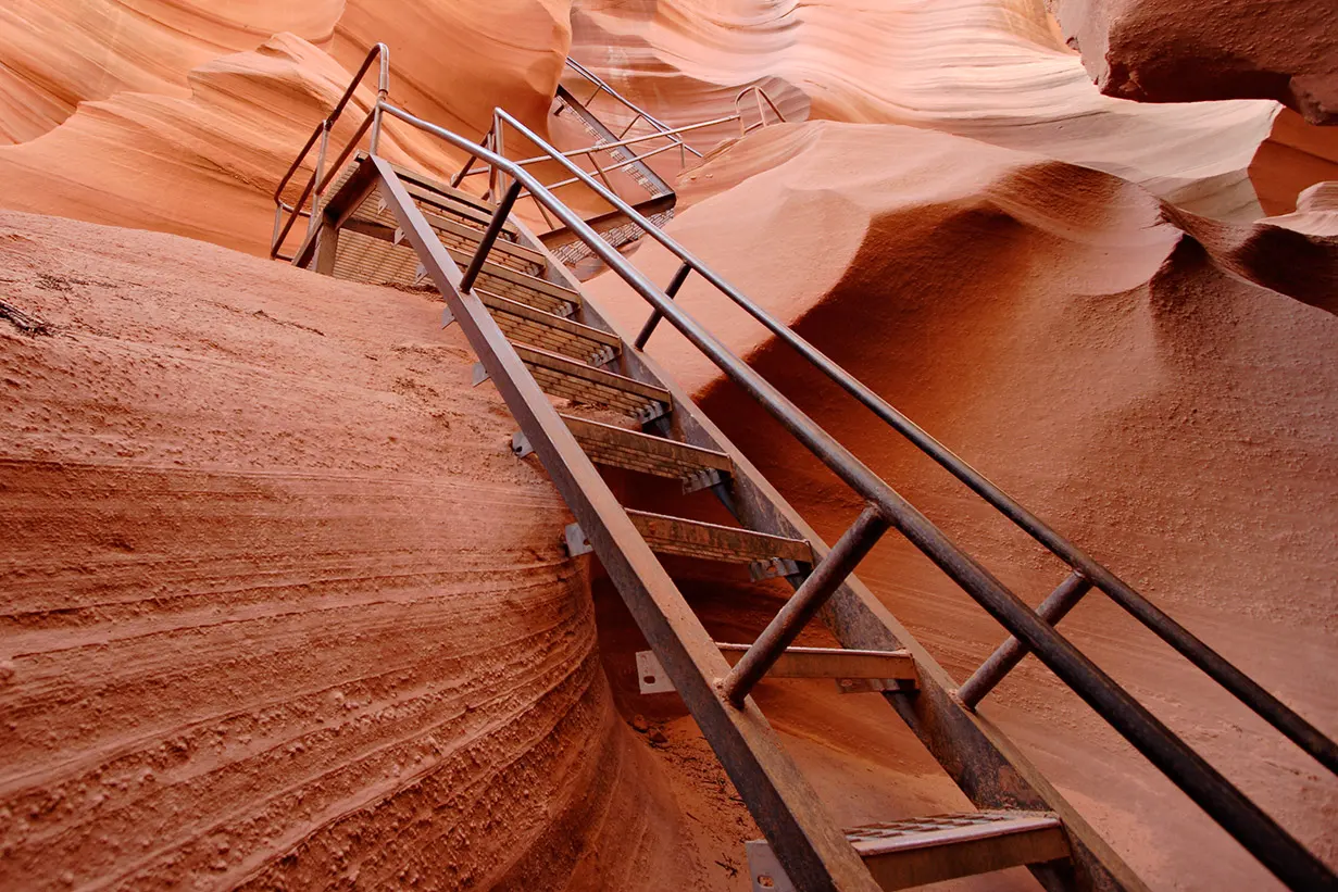 Steel stairway with handrails bolted into the sandstone wall of Lower Antelope Canyon