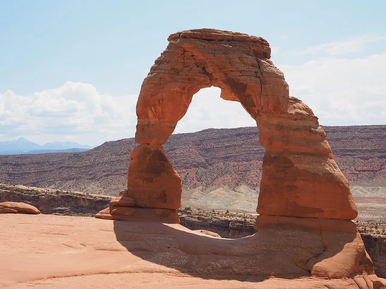 Delicate Arch freestanding orange sandstone arch against blue sky in Arches National Park
