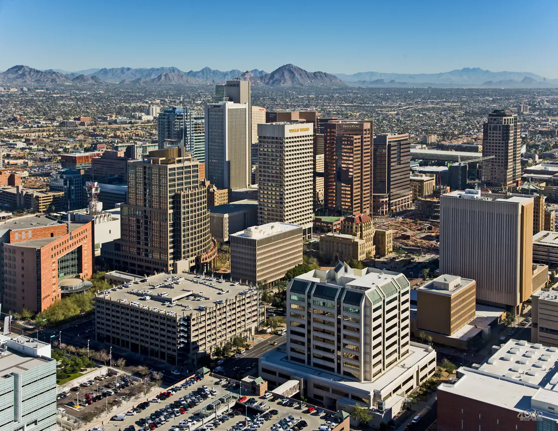 Aerial view of downtown Phoenix towers with the Sonoran Desert and mountains beyond