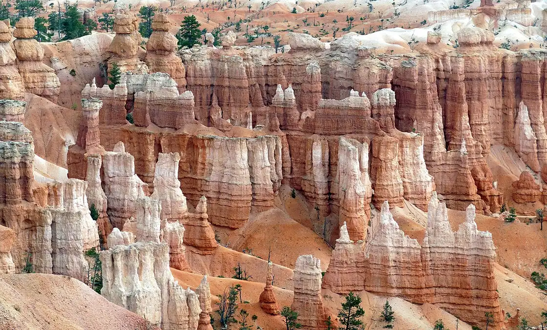 Tall hoodoo formations and cliffs glowing in sunlight at Bryce Canyon National Park