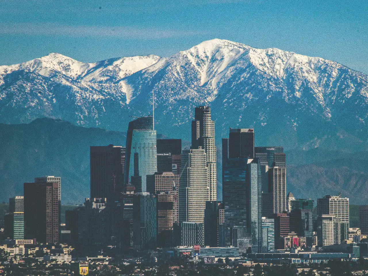Downtown Los Angeles skyline with snow-dusted mountains behind on a clear winter day