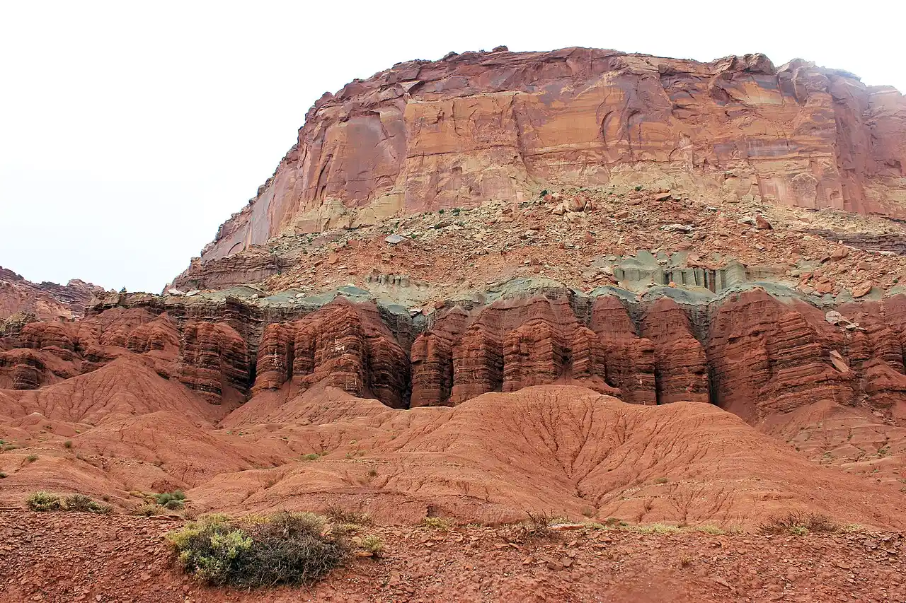 Layered red and cream sandstone cliffs rising above the desert floor at Capitol Reef National Park