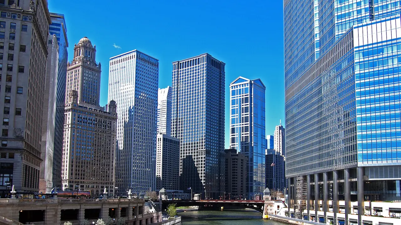 A sightseeing boat on the Chicago River passing between downtown towers