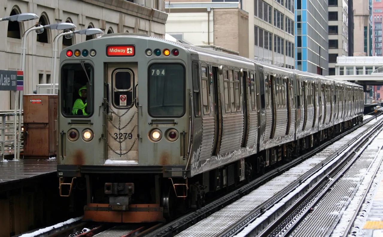 A CTA elevated train rounding a curve on the Loop tracks above a Chicago street