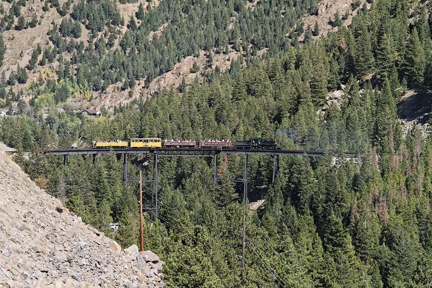 A narrow-gauge steam train crossing the high trestle on the Georgetown Loop Railroad