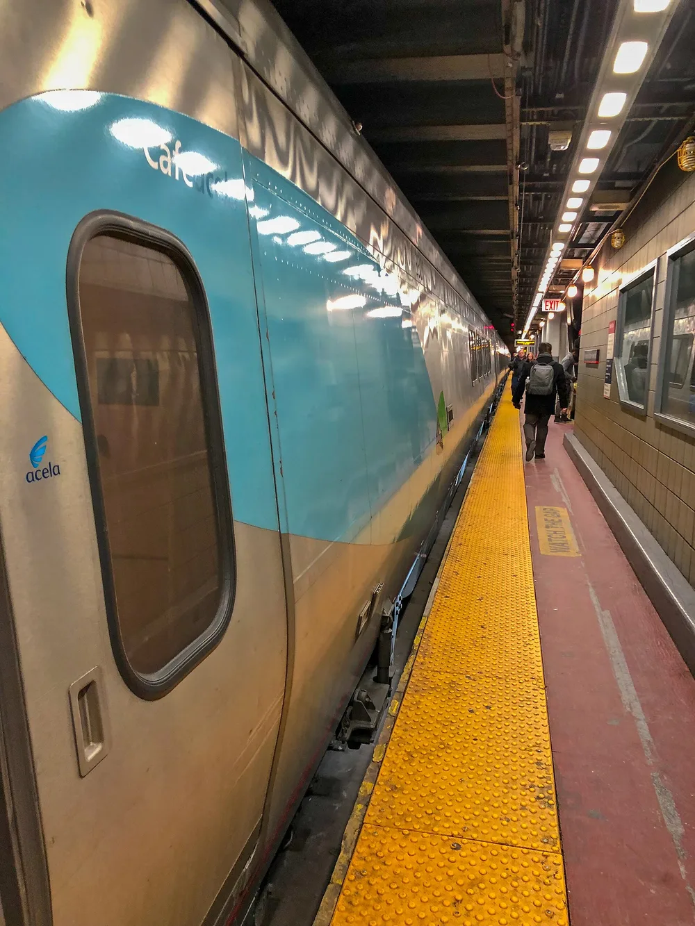 An Amtrak Acela train standing at a platform in New York Penn Station