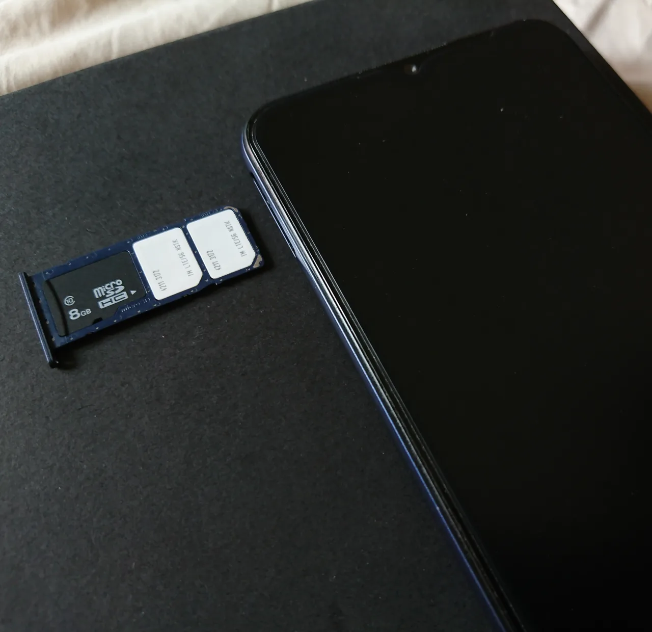 A dual SIM tray ejected from a modern smartphone showing two SIM cards