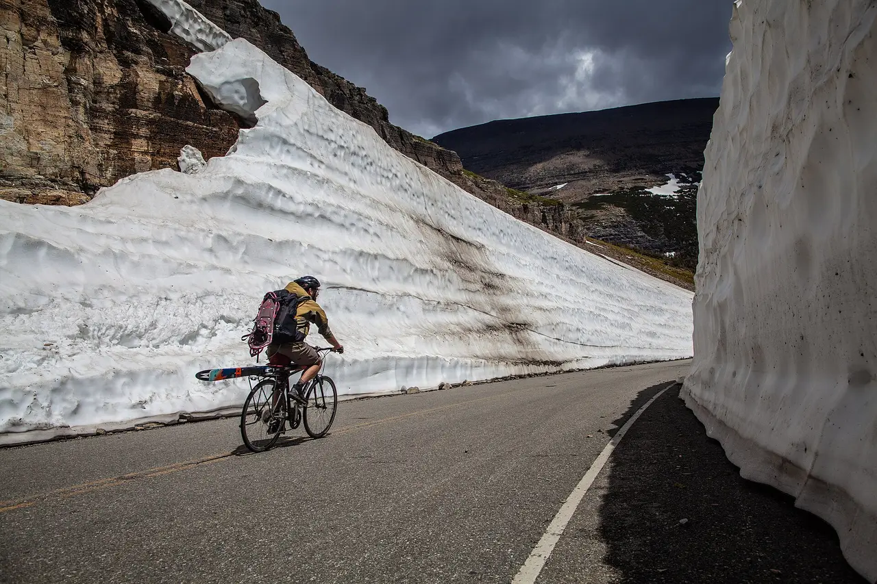 Cyclists riding Going-to-the-Sun Road with mountain peaks ahead in Glacier National Park