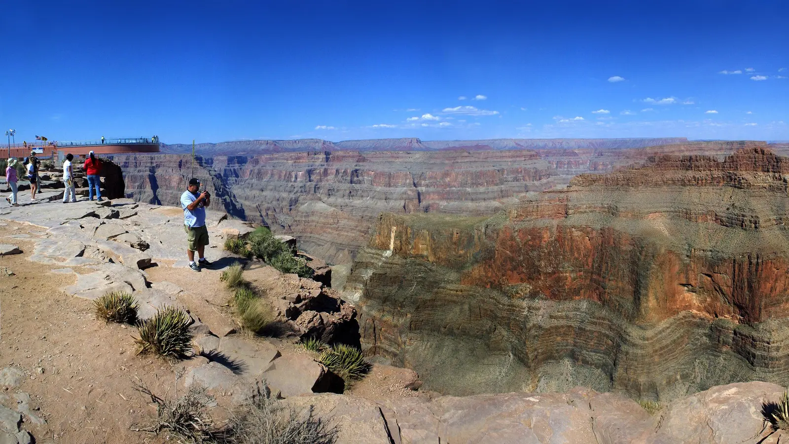 Visitors photographing the horseshoe-shaped glass Skywalk bridge extending over the Grand Canyon at Grand Canyon West