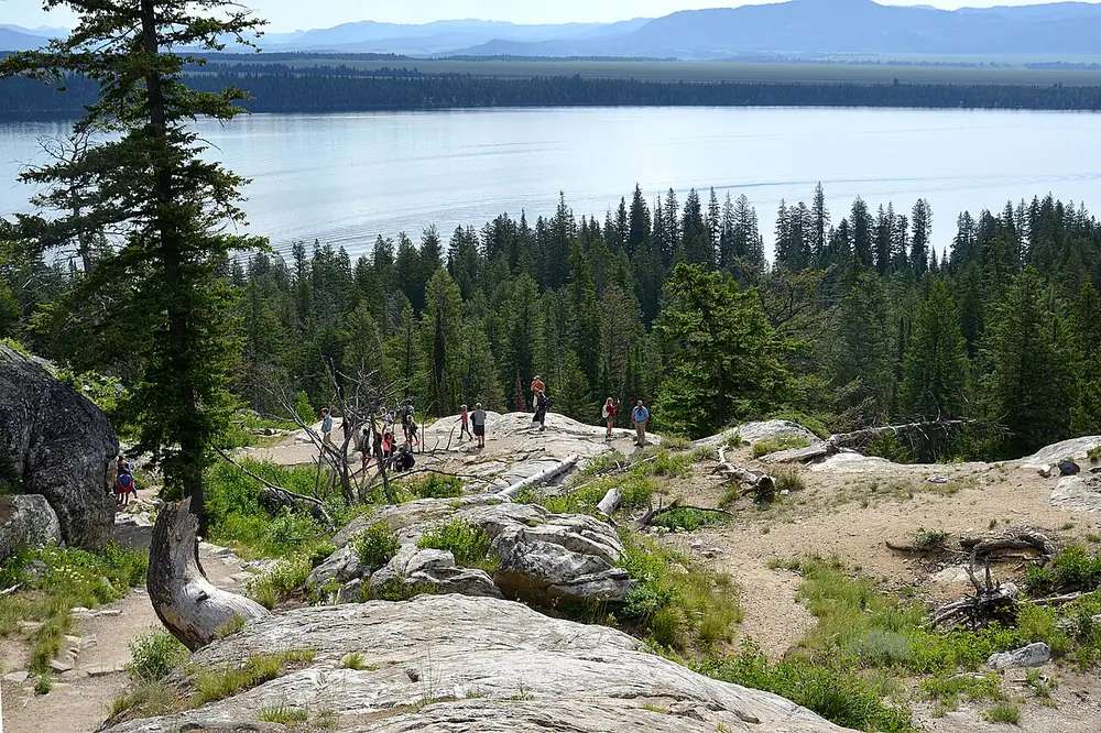 Hikers on an overlook above Cascade Canyon in the Teton Range