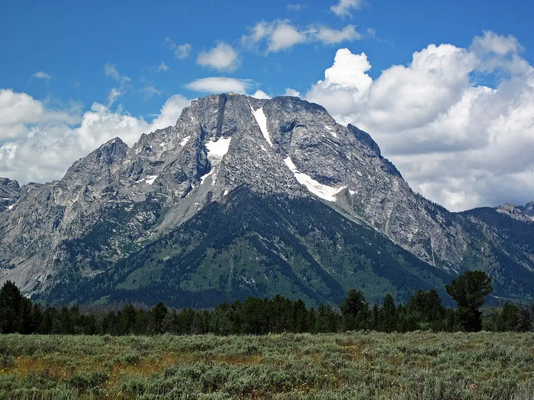 Mount Moran and neighboring Teton peaks above forest and meadow in Grand Teton National Park