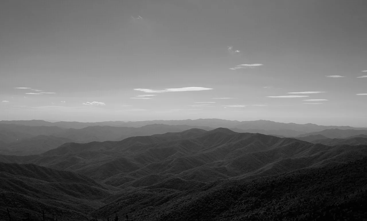 Forested Smoky Mountain slopes in October with patches of yellow and orange fall foliage