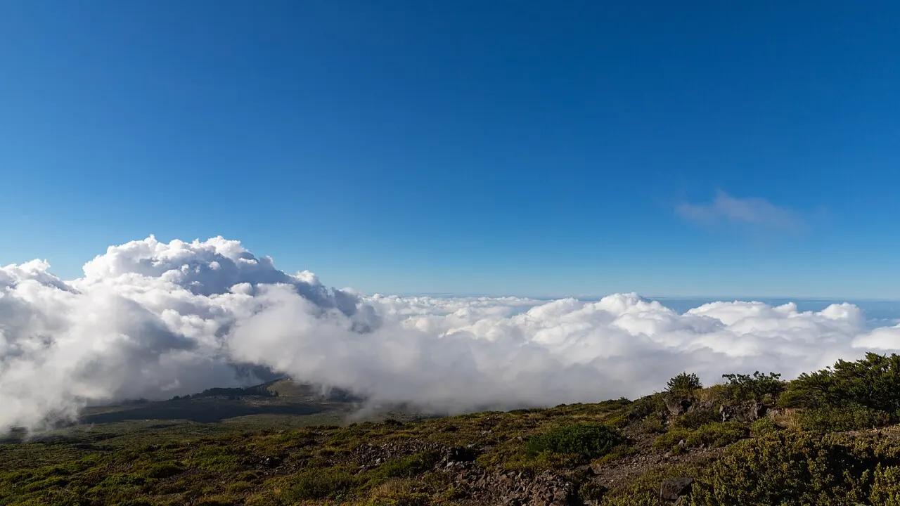 Sunlit cloud layer below the summit of Haleakala on Maui with volcanic slopes in the foreground
