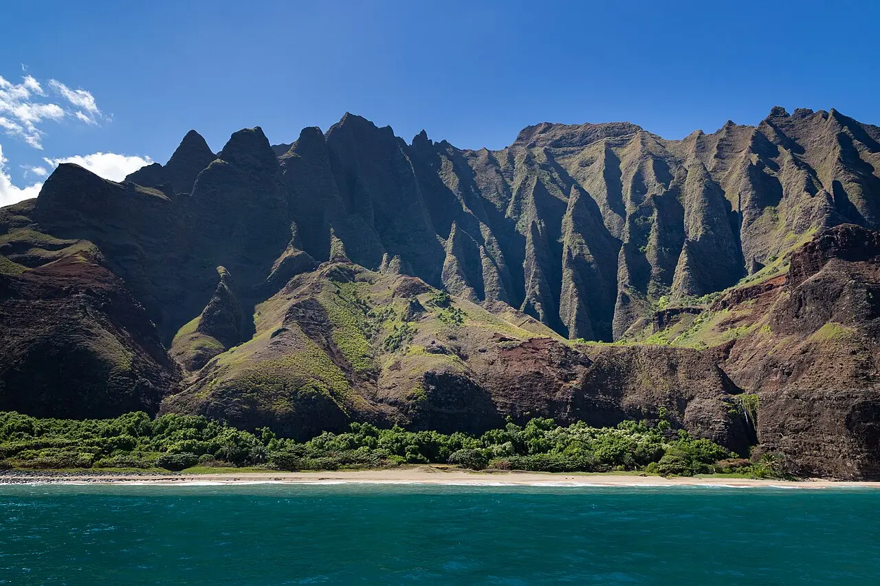 The green fluted cliffs of the Na Pali Coast on Kauai dropping into the Pacific