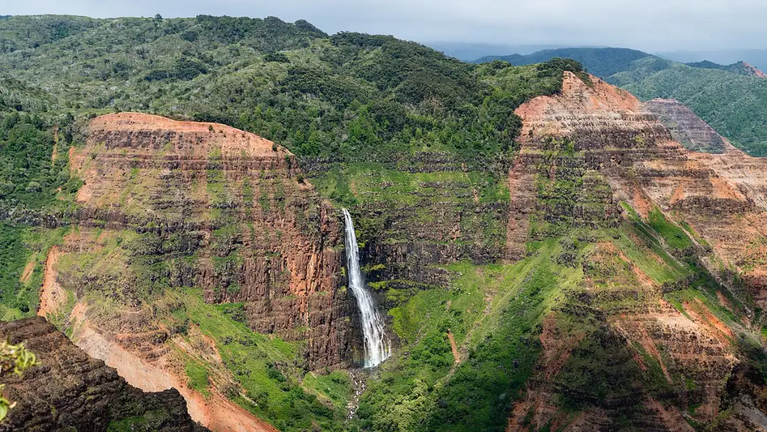Waipoo Falls dropping down the red and green walls of Waimea Canyon on Kauai