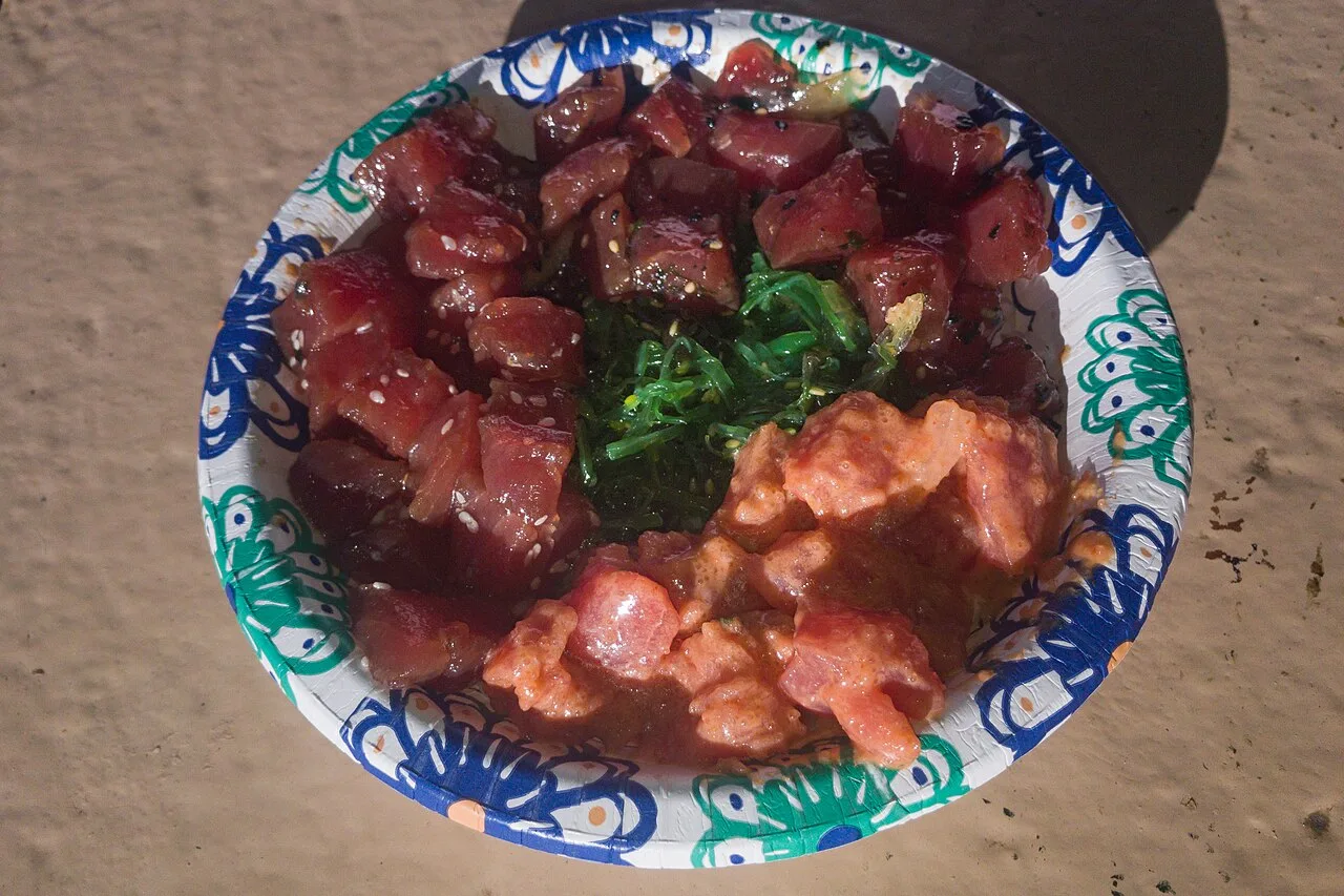 A bowl of Hawaiian poke with cubed raw fish over rice