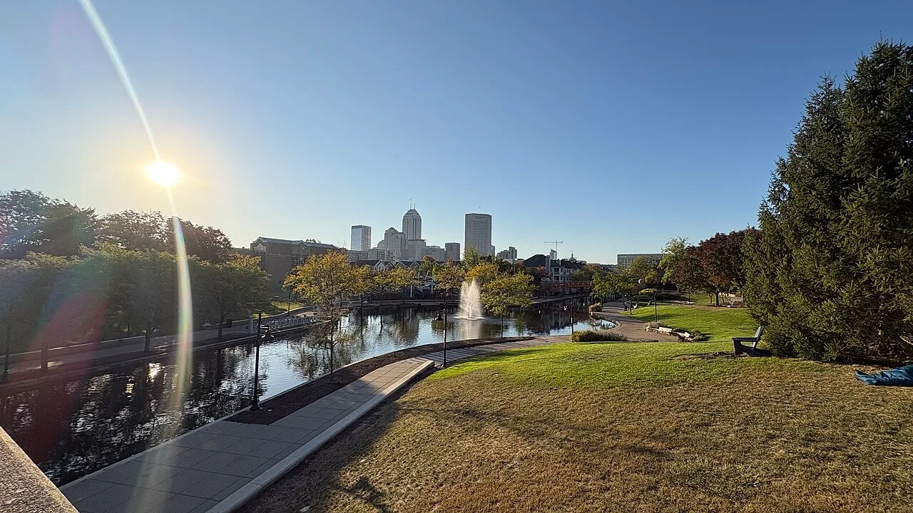 Indianapolis skyline and canal walk under clear sky with fall color in the trees along the water