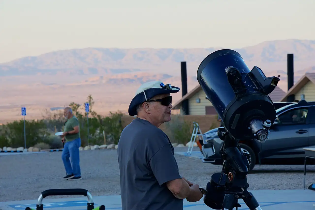 Visitor using a telescope under the night sky in Joshua Tree National Park