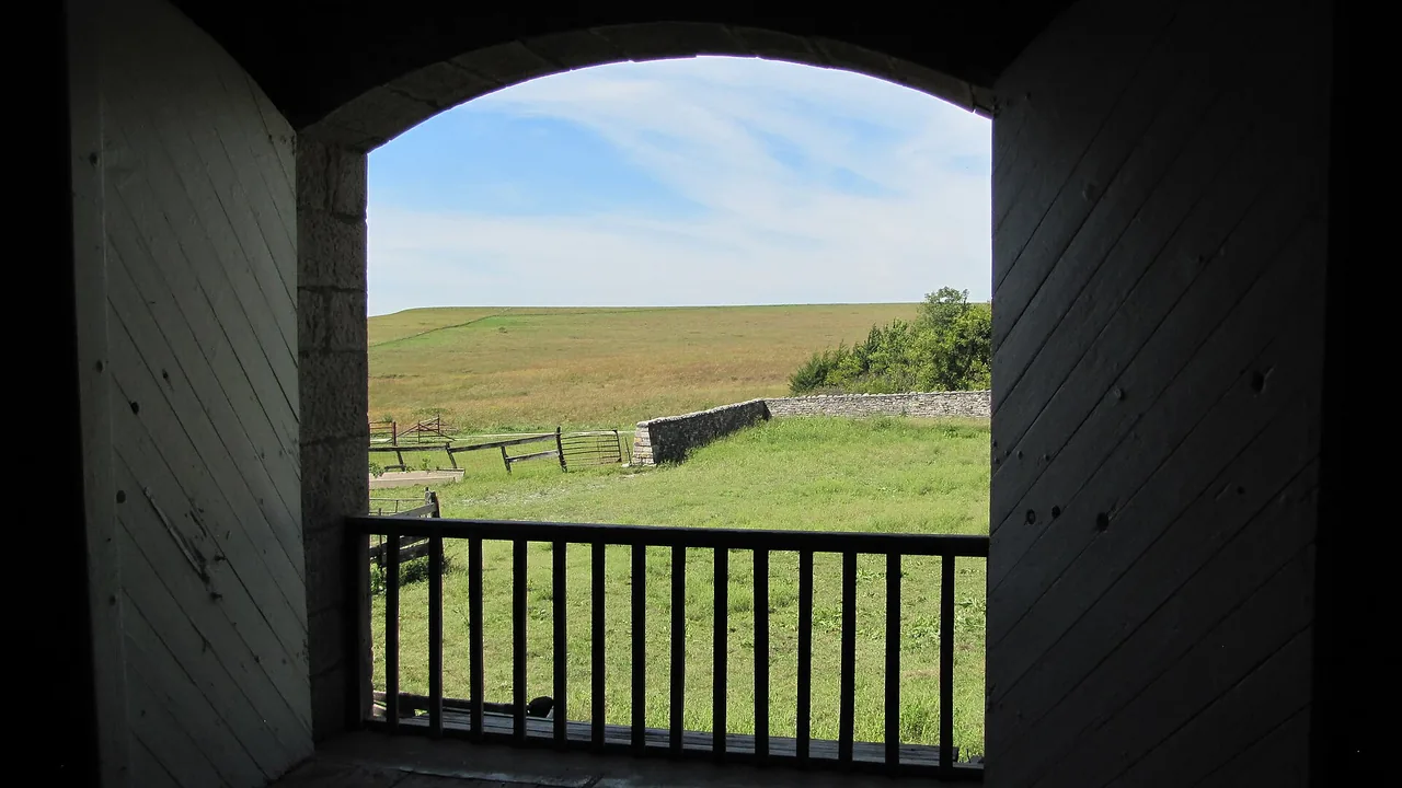 Tallgrass prairie viewed through an opening in the historic limestone barn at Tallgrass Prairie National Preserve