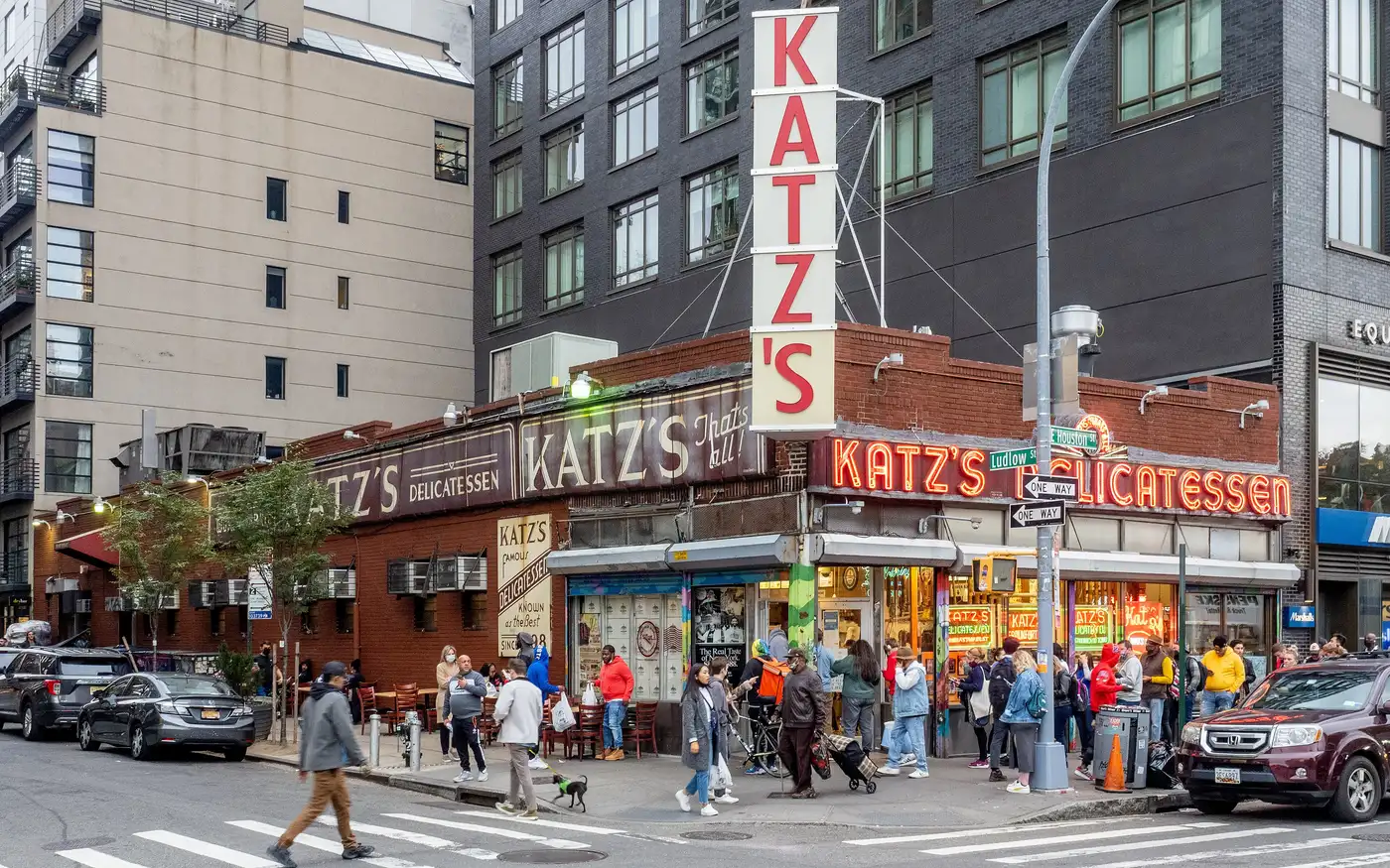 Crowds outside the corner storefront of Katz's Delicatessen with its red neon sign on Houston Street