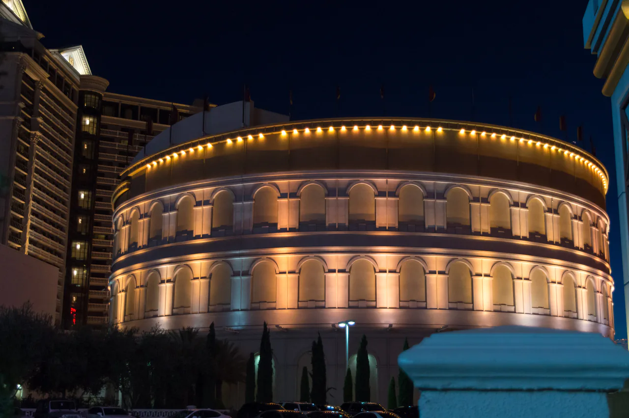 The replica Colosseum theater at Caesars Palace lit up on the Las Vegas Strip in the evening