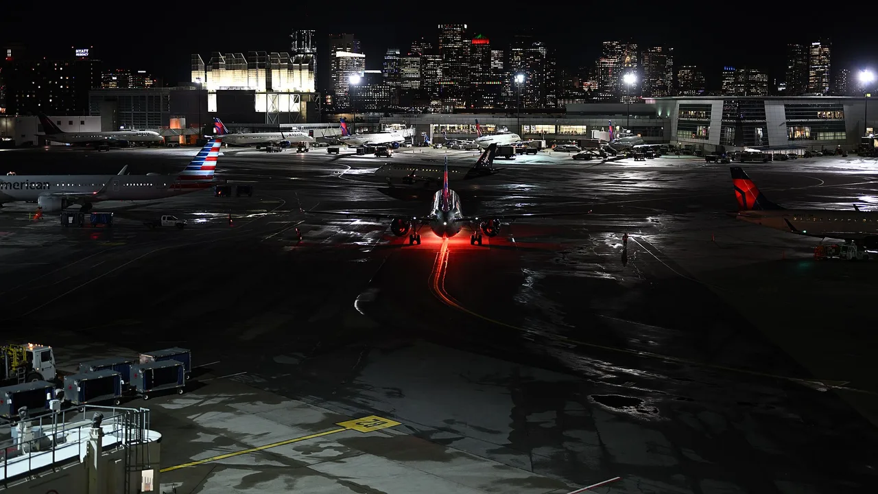 Aircraft parked at Terminal A and Terminal B gates at Boston Logan International Airport at night