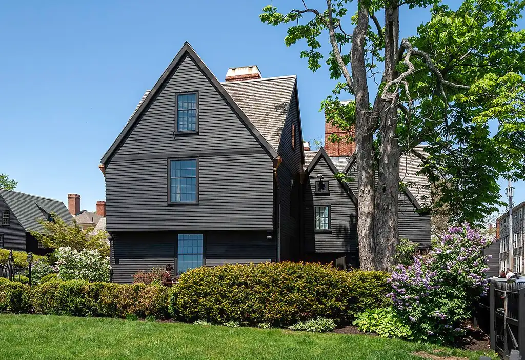 The dark clapboard House of the Seven Gables with its gables and chimney in Salem, Massachusetts