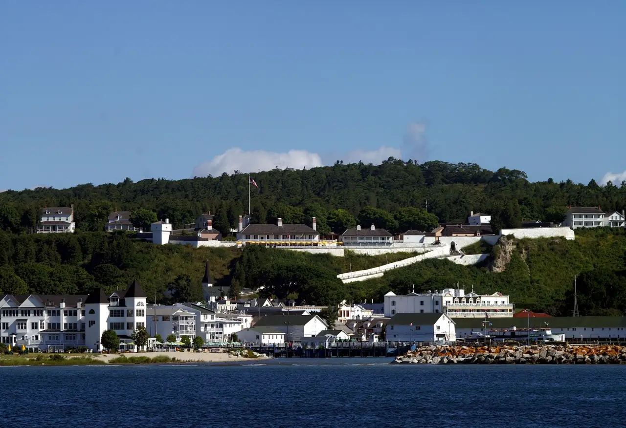 White buildings of Fort Mackinac on the bluff above the island harbor