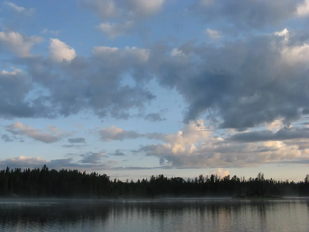 Calm lake reflecting pine trees in the Boundary Waters wilderness