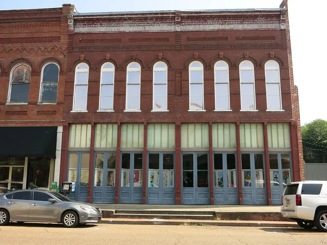 Brick commercial building with arched windows on a Natchez street