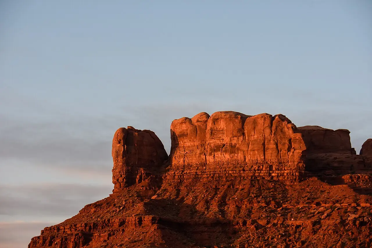 A sandstone butte glowing orange in the sunset light at Monument Valley