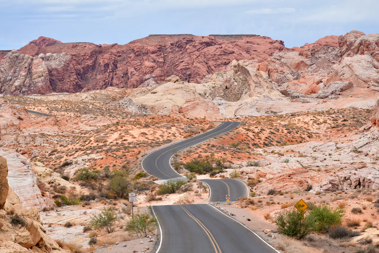 A paved road winding between red Aztec sandstone formations in Valley of Fire State Park, Nevada