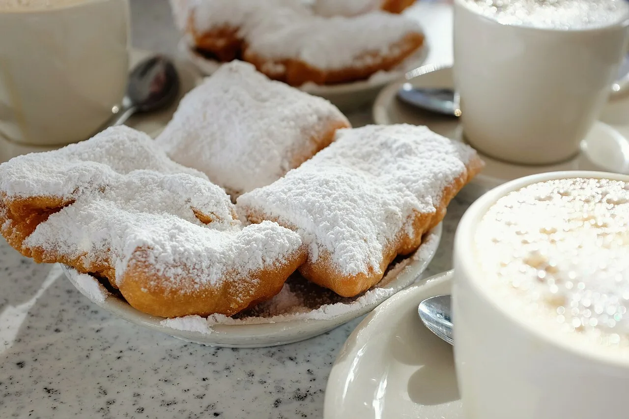 A plate of powdered-sugar beignets with cafe au lait at Cafe du Monde in New Orleans