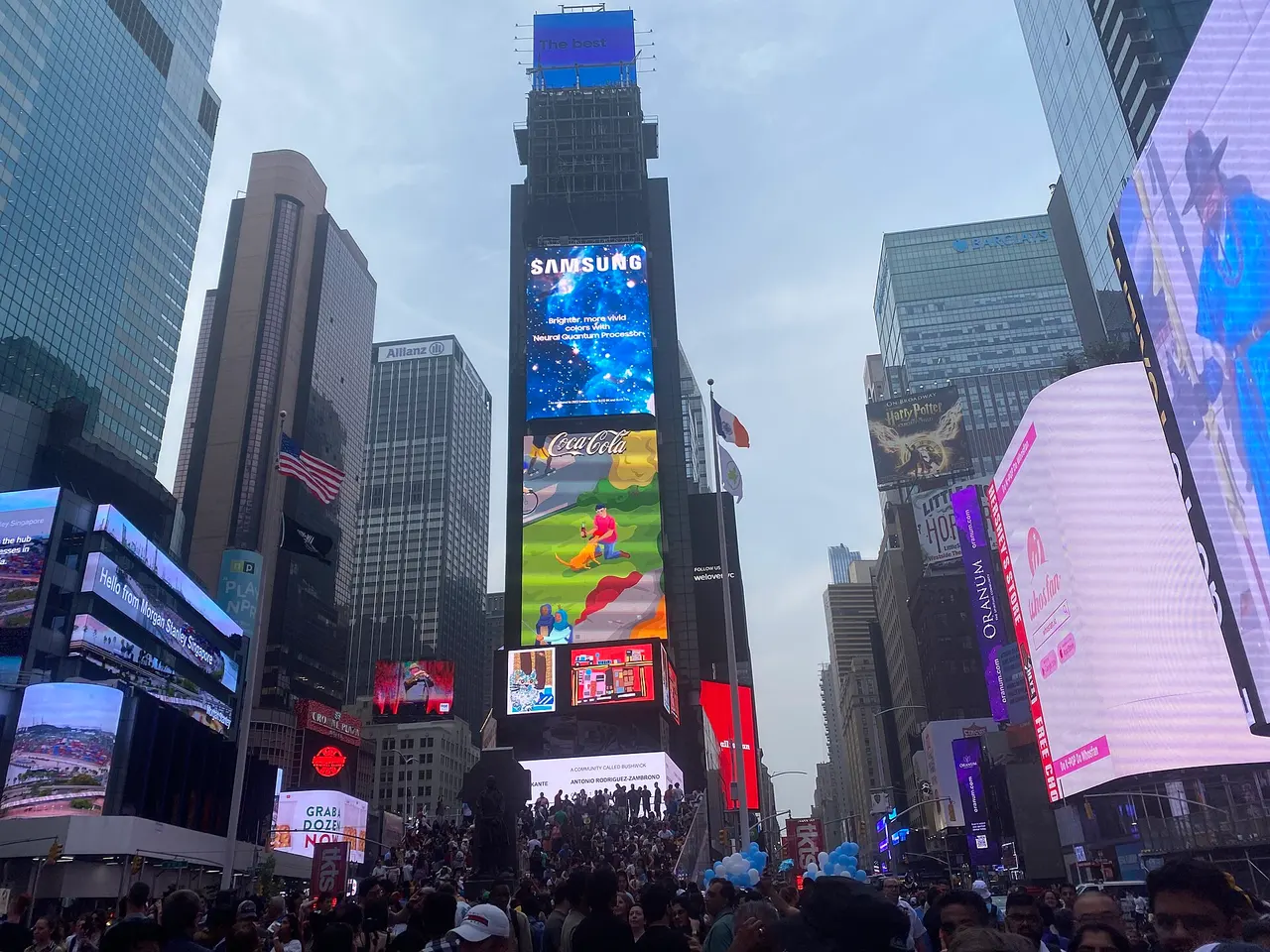 Times Square filled with pedestrians and bright billboards in daylight