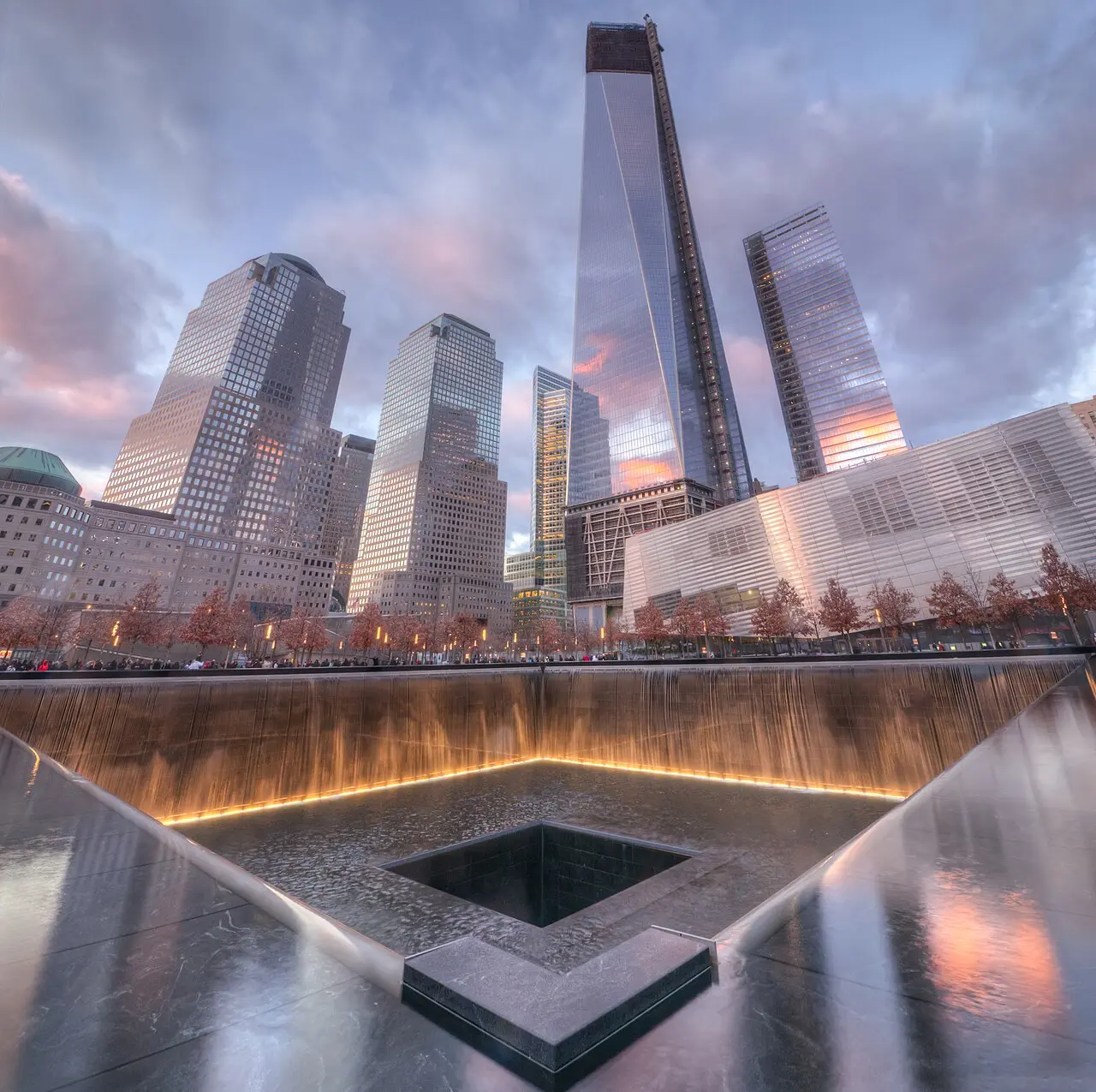 One of the sunken reflecting pools of the National September 11 Memorial with names cut into the bronze parapet