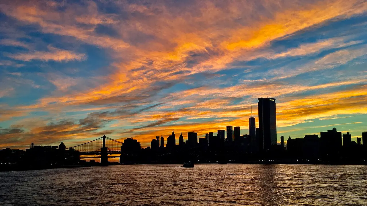 The Lower Manhattan skyline at sunset seen across New York Harbor