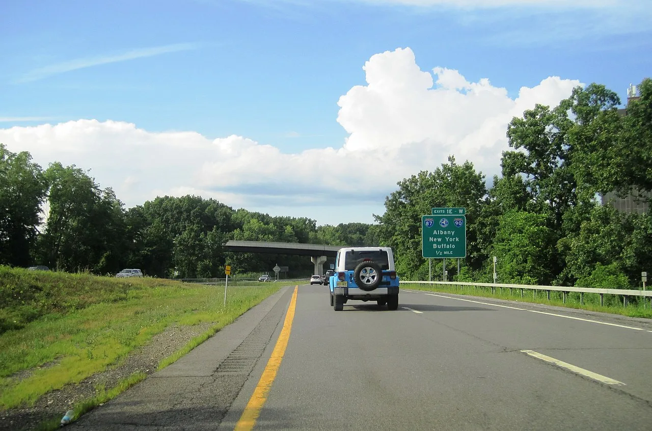 A New York State Thruway sign on a highway approaching Interstates 87 and 90