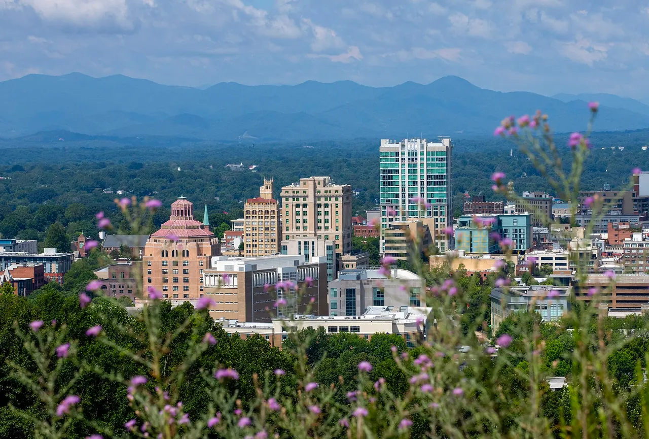 The downtown Asheville skyline with the Blue Ridge Mountains behind it