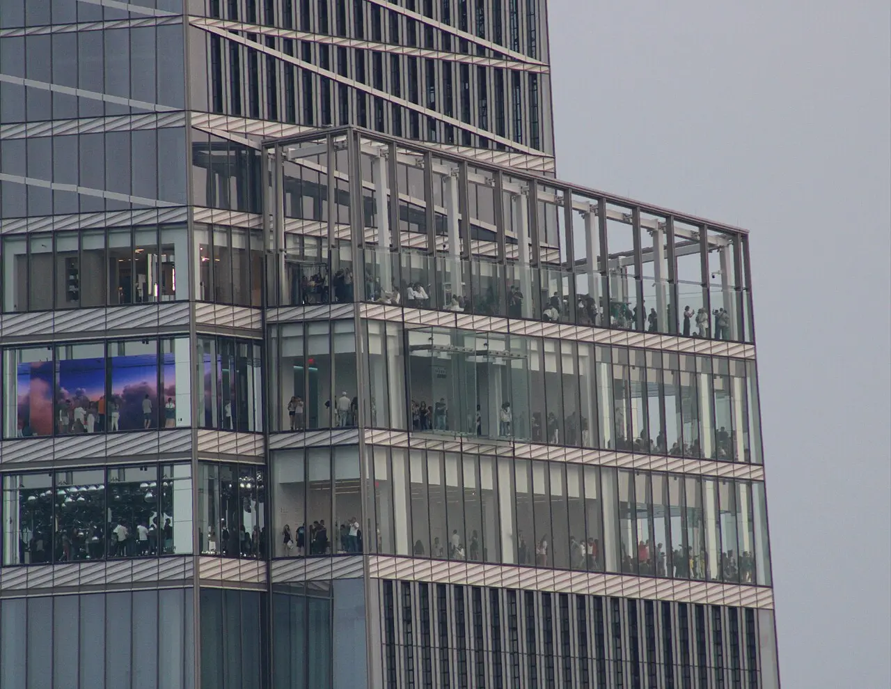 SUMMIT One Vanderbilt's glass box floors seen from Top of the Rock, with people visible on the terraces