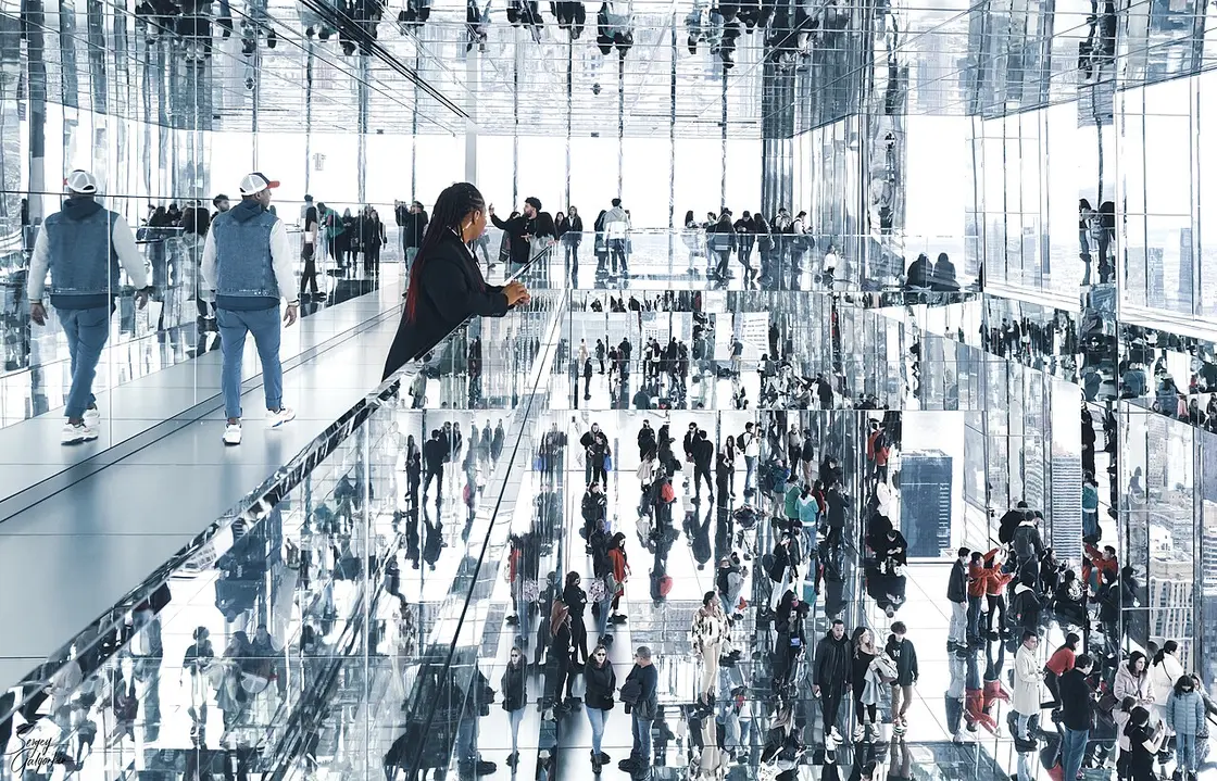 Visitors reflected infinitely in the mirrored floor and walls of the SUMMIT One Vanderbilt art installation