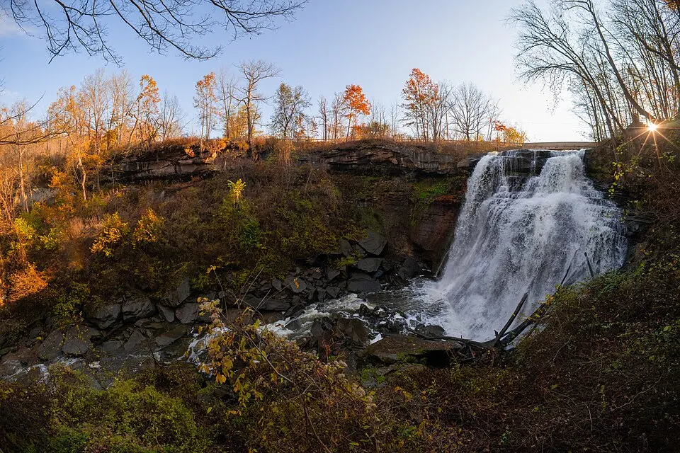 Brandywine Falls cascading over a rock ledge surrounded by fall foliage in Cuyahoga Valley National Park