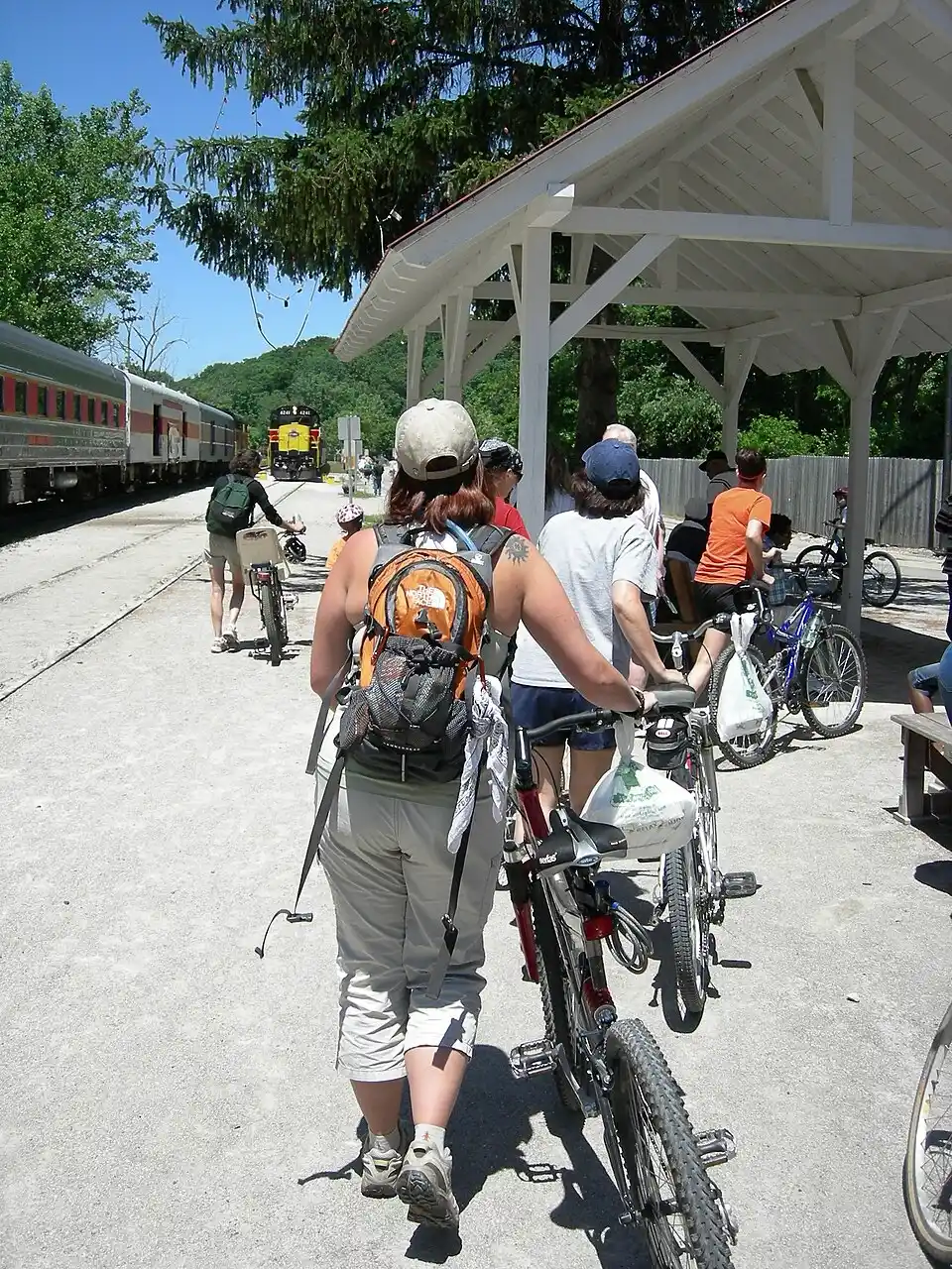 Cyclists waiting at a covered station platform beside the Cuyahoga Valley Scenic Railroad train