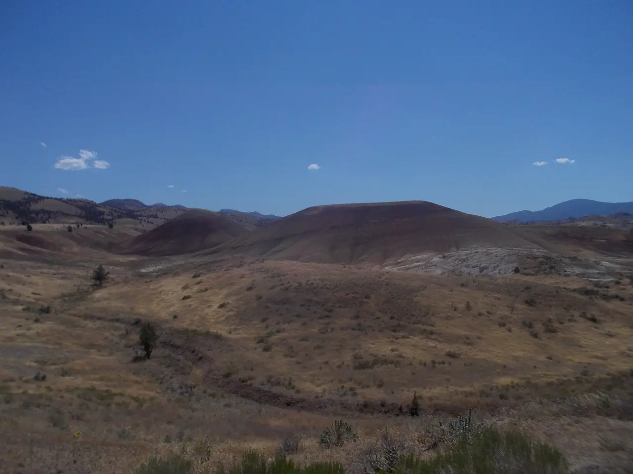 Banded red and gold slopes of the Painted Hills under a clear blue sky in eastern Oregon
