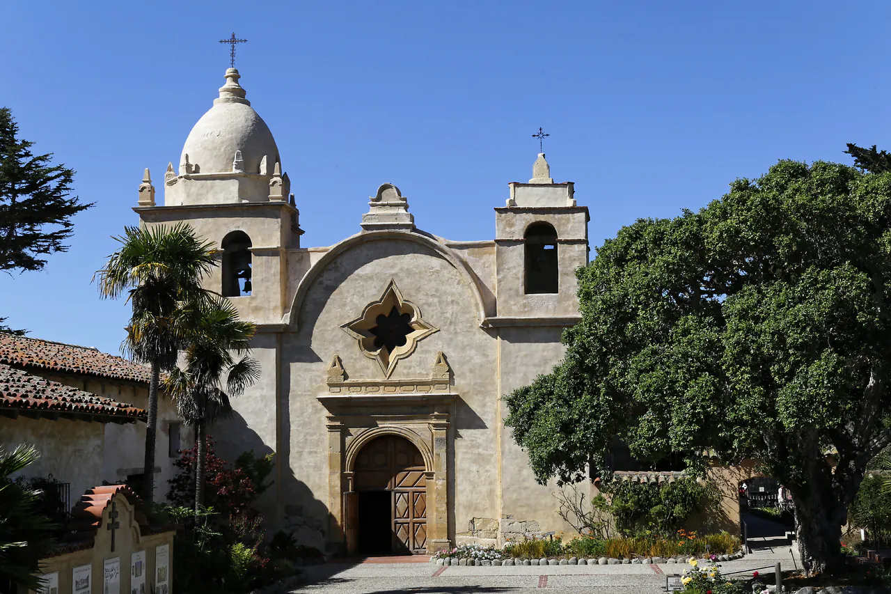 The stone facade and bell tower of the Carmel Mission in California