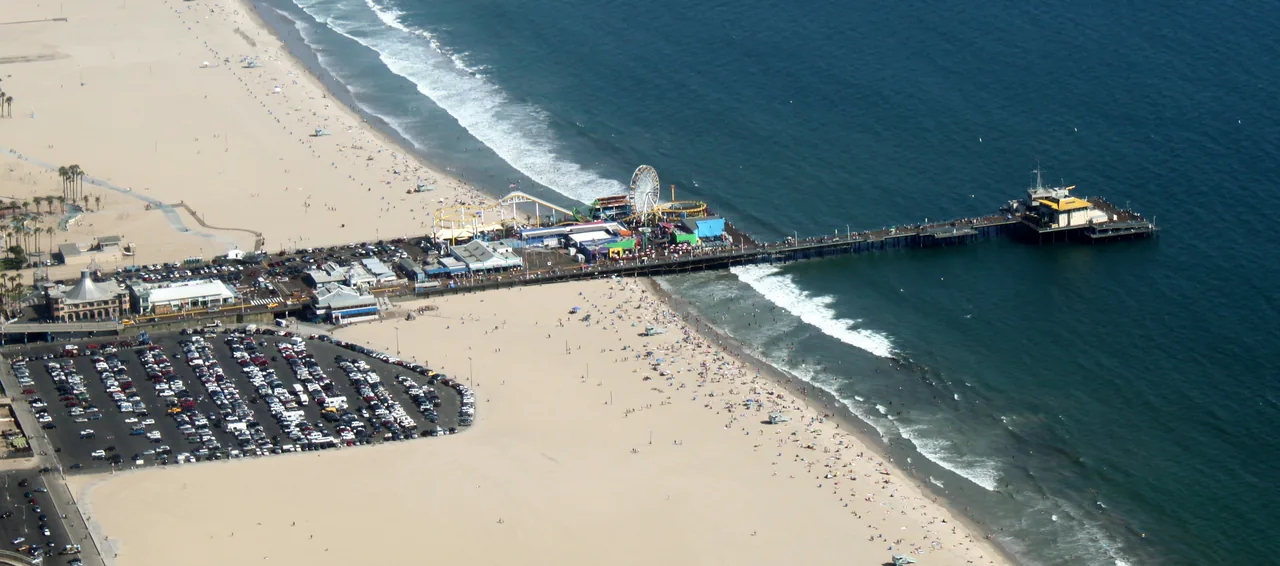 Aerial view of the Santa Monica Pier and the beach curving south